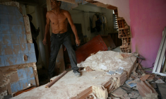 Wilman Gonzalez aide à nettoyer un appartement endommagé à Catia La Mar, dans l'État de La Guaira, au Venezuela, le 4 janvier 2026 ( AFP / Federico PARRA )