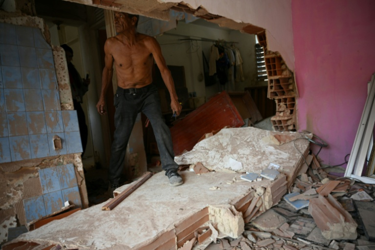 Wilman Gonzalez aide à nettoyer un appartement endommagé à Catia La Mar, dans l'État de La Guaira, au Venezuela, le 4 janvier 2026 ( AFP / Federico PARRA )