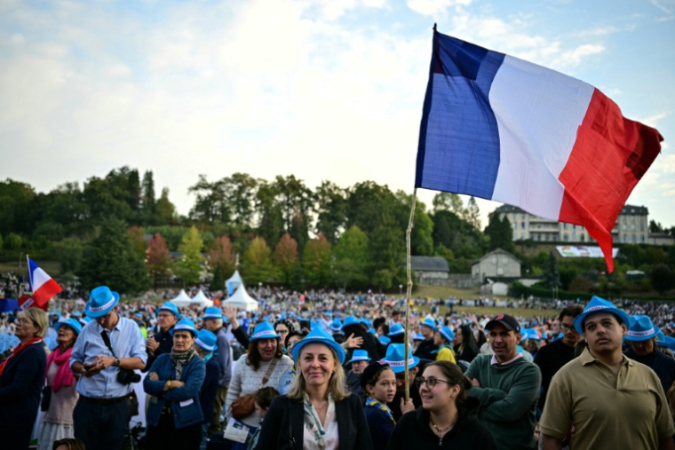 Des fidèles attendent l'arrivée du pape Léon XIV, le 27 septembre 2026 sur la prairie du sanctuaire à Lourdes, dans le sud-ouest de la France  ( AFP / Lionel BONAVENTURE )