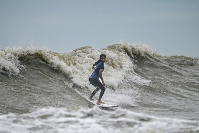 La surfeuse bangladaise Fatima Akhter pratique son sport à Cox's Bazar, dans le sud-est du Bangladesh, le 22 juin 2026   ( AFP / Munir UZ ZAMAN )