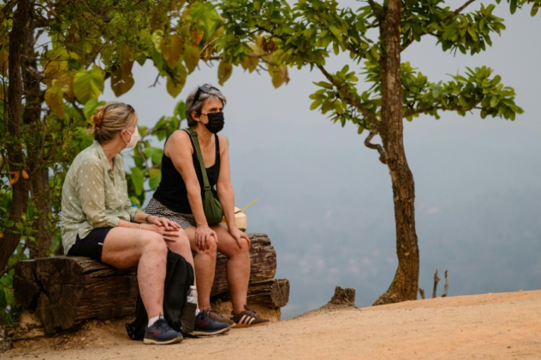 Des touristes portent un masque pour visiter le canyon de Pai, dans le nord de la Thaïlande, le 1er avril 2026 ( AFP / ANTHONY WALLACE )