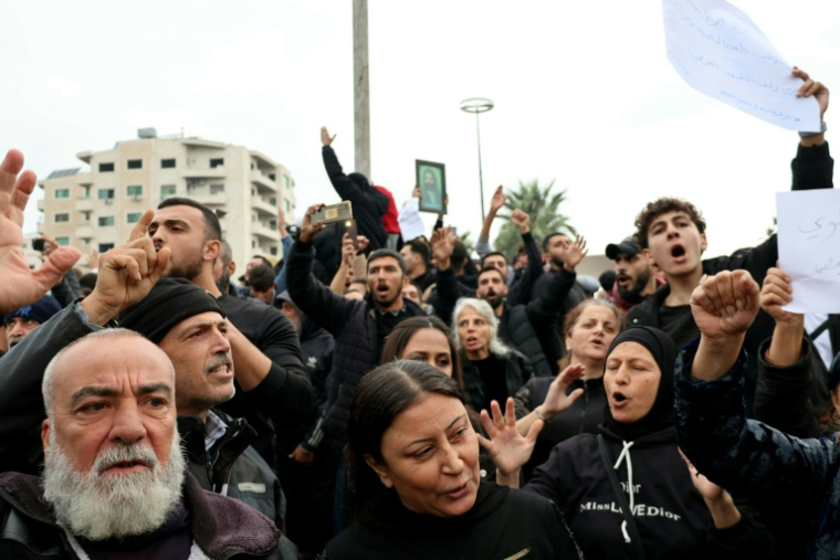 Des personnes participent à une manifestation dans la ville côtière de Lattaquié, fief alaouite de Syrie, le 25 novembre 2025 ( AFP / Haidar MUSTAFA )