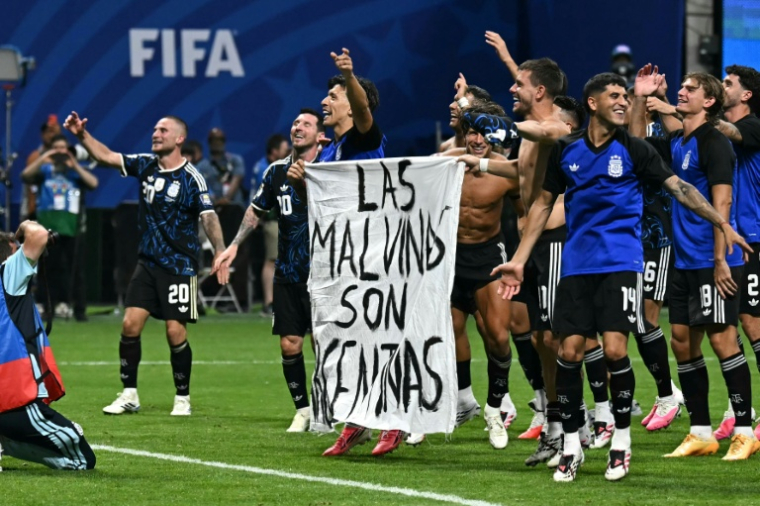 Des joueurs argentins déploient une banderole "Les Malouines sont argentines" après la victoire contre l'Angleterre en demi-finale du Mondial-2026 le 15 juillet 2026 à Atlanta ( AFP / Paul ELLIS )