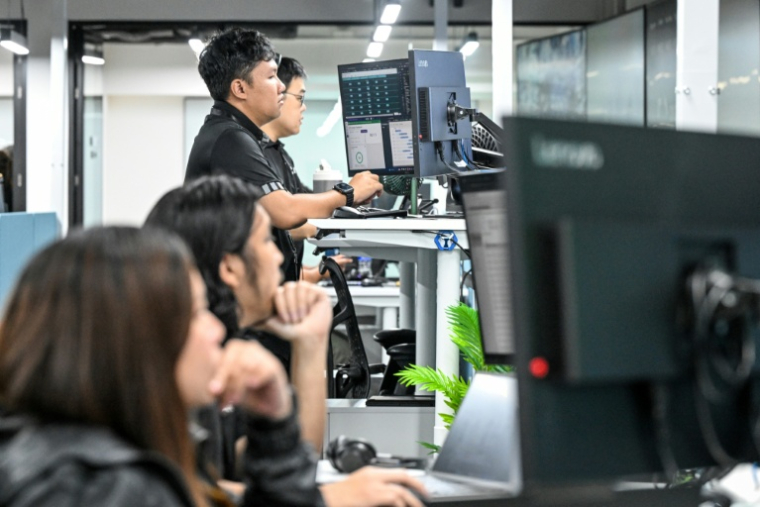 Des analystes au centre de commandement de la société américaine Digital Realty, le 2 septembre 2026 à Singapour  ( AFP / Roslan RAHMAN )