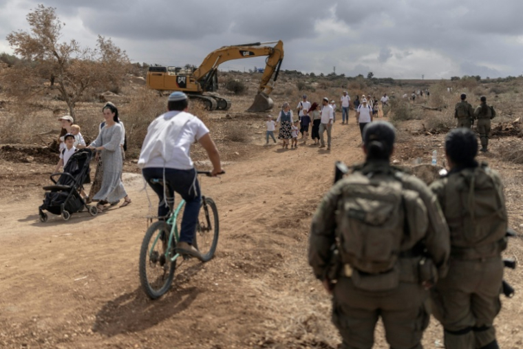 Des familles israéliennes marchent sur la route reliant les colonies de Ganim et de Kadim, à la périphérie de la ville palestinienne de Jénine, en Cisjordanie occupée, le 30 septembre 2026 ( AFP / Ilia YEFIMOVICH )
