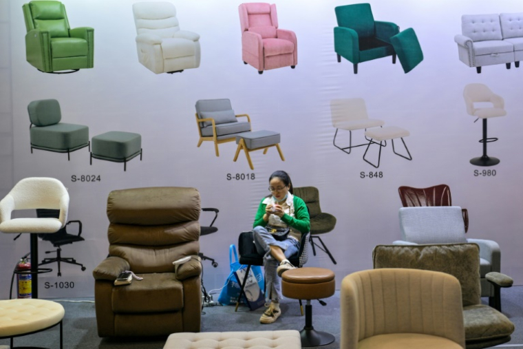 Une femme sur un stand de fauteuils lors de la foire-exposition à Ningbo, dans la province du Zhejiang, le 28 mai 2025 en Chine ( AFP / Hector RETAMAL )