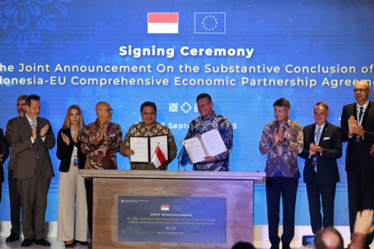 Le ministre indonésien de l'Economie, Airlangga Hartarto (au centre à g.), et le commissaire européen au commerce, Maros Sefcovic (au centre à d.), posent sur scène après avoir paraphé l'accord de libre-échange entre l'Indonésie et l'UE sur l'île indonésienne de Bali, le 23 septembre 2025 ( AFP / Sonny TUMBELAKA )