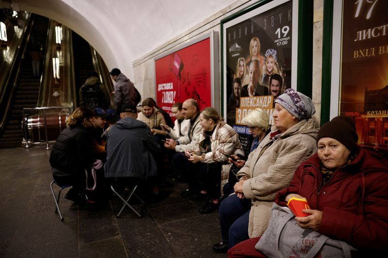Des personnes s'assoient dans une station de métro pour s'abriter d'un raid aérien à Kiev.