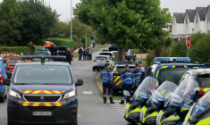 Les gendarmes bloquent la circulation à côté d'un immeuble où un homme, soupçonné d'avoir tué une femme, s'est barricadé, le 4 septembre 2026 à Plourin-lès-Morlaix, dans le Finistère ( AFP / Fred TANNEAU )