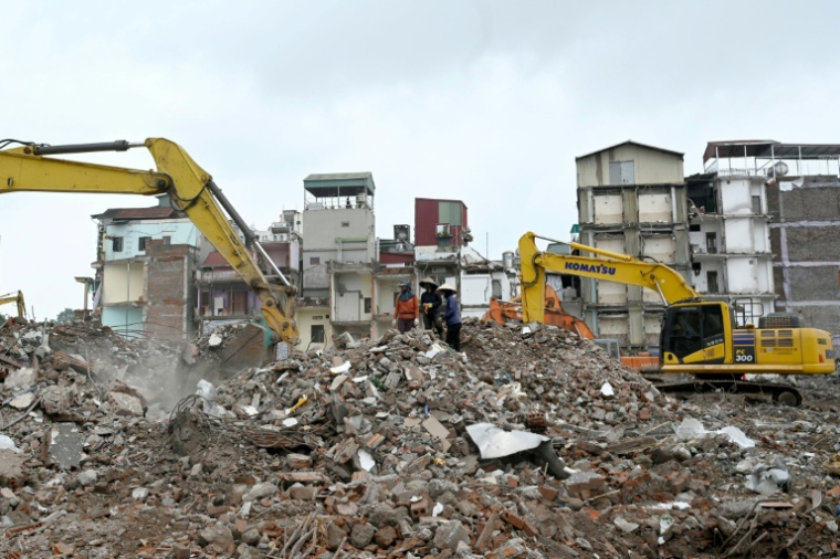 Des ouvriers récupèrent du métal sur un chantier de démolition à Hanoï, le 18 mai 2026 ( AFP / Nhac NGUYEN )