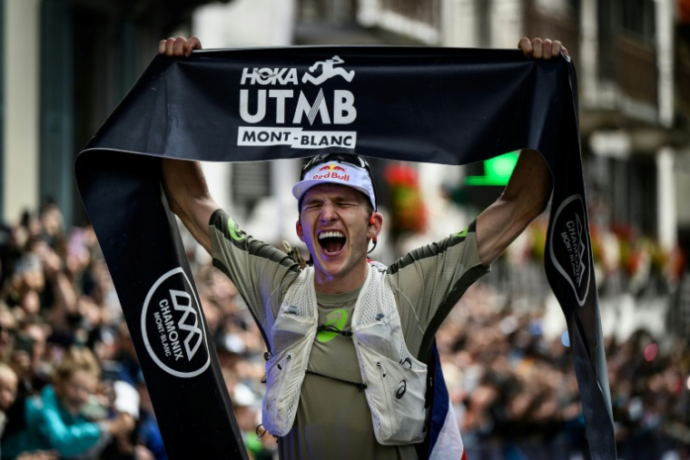 Le Britannique Tom Evans célèbre sa victoire au terme de l'UTMB, à Chamonix, le 30 août 2025 ( AFP / JEFF PACHOUD )