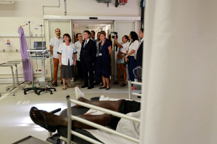 Le ministre des Outre-mer Manuel Valls échange avec des soignants lors d'une visite à l'hôpital de Saint-Paul, à La Réunion, le 7 avril 2025 ( AFP / Richard BOUHET )