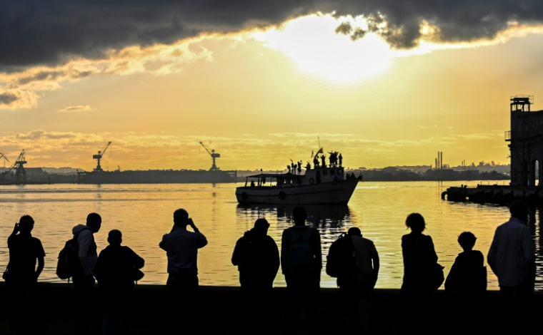 Des habitants regardent le bateau Maguro du convoi international "Nuestra America" transportant de l'aide humanitaire pour Cuba, dans le port de La Havane, le 24 mars 2026 ( AFP / YAMIL LAGE )