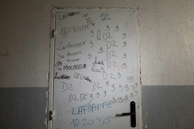 Une porte avec des inscriptions faisant référence à la vente de drogue illégale et à la DZ Mafia dans la cité de La Maurelette à Marseille 16 janvier 2026 ( AFP / MIGUEL MEDINA )