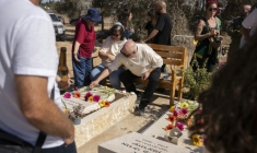 Des habitants du kibboutz Kfar Aza fleurissent les tombes de victimes de l'attaque du 7 octobre 2023, le 16 octobre 2023 à Kfar Aza ( AFP / Maya Levin )