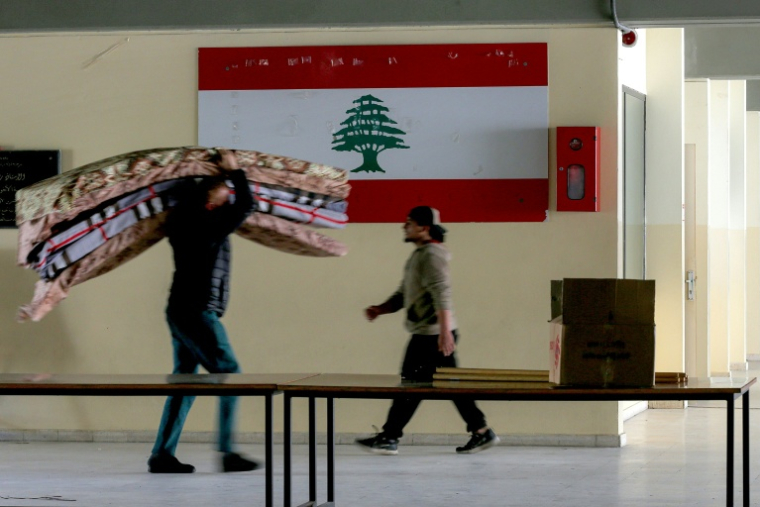 Un bénévole transporte des matelas pour les personnes déplacées du sud du Liban, dans une école transformée en abri à Saïda, le 17 mars 2026 ( AFP / MAHMOUD ZAYYAT )