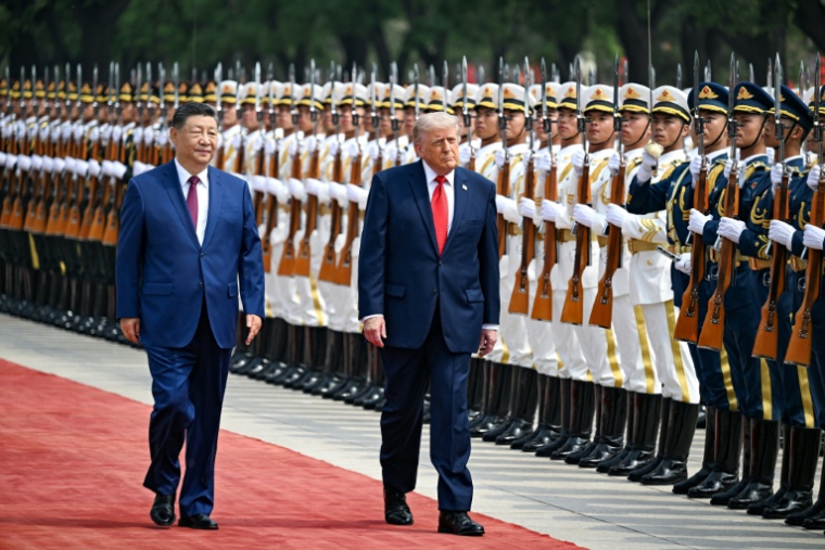 Le président américain Donald Trump (droite) et son homologue chinois Xi Jinping passent des troupes en revue, le 14 mai 2026 à Pékin ( POOL / Kenny HOLSTON )