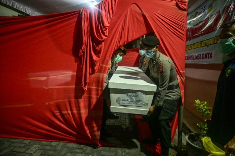 Des policiers transportent le cercueil d'un étudiant, le 5 octobre 2025 à l'hôpital Bhayangkara de Surabaya, tué dans l'effondrement d'un bâtiment de l'internat islamique Al Khoziny à Sidoarjo, en Indonésie ( AFP / JUNI KRISWANTO )