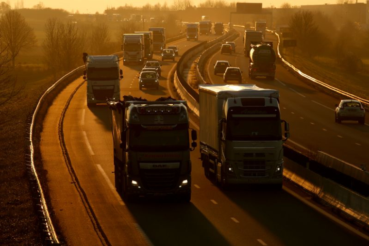 Des camions et des voitures circulent sur l'autoroute Paris-Bruxelles au coucher du soleil à Tilloy-lez-Cambrai