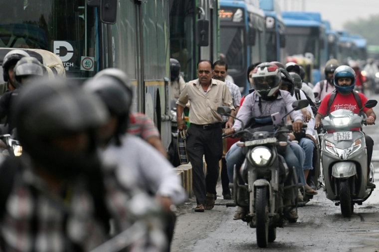 Des piétons au milieu de la circulation sur un pont à New Delhi, le 8 juillet 2026 en Inde ( AFP / Arun SANKAR )