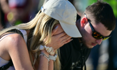 A woman reacts as mourners lay flowers during a gathering marking the first anniversary of the Novi Sad railway station tragedy, in Novi Sad, on November 1, 2025.  Tens of thousands are expected in Serbia's second largest city Novi Sad to commemorate victims of a railway station collapse a year ago that triggered mass protests. On November 1, 2024, the collapse of the canopy at the newly-renovated railway station in Novi Sad killed 16 people. Regular student-led protests have gripped the Balkan nation since the tragedy, which became a symbol of entrenched corruption. ( AFP / Andrej ISAKOVIC )