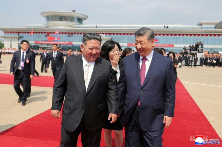 Photo, prise le 9 juin 2026 et mise à disposition par l'agence de presse officielle nord-coréenne KCNA, du leader nord-coréen Kim Jong Un (G) avec le président chinois Xi Jinping (D) à l'aéroport de Pyongyang ( KCNA VIA KNS / STR )