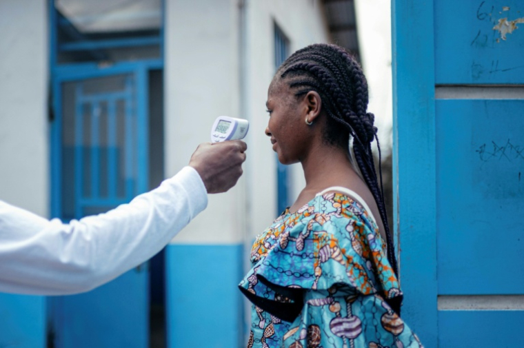 Un membre du personnel de l'hôpital CBCA Virunga prend la température d'une visiteuse à l'aide d'un thermomètre infrarouge sans contact avant de l'autoriser à entrer dans l'hôpital de Goma, en République démocratique du Congo, le 17 mai 2026.  ( AFP / Jospin Mwisha )