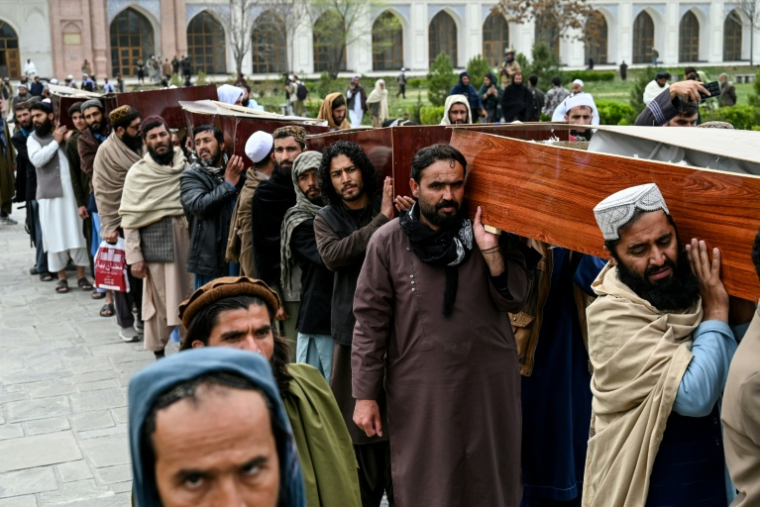 Des hommes portent les cercueils des victimes tuées lors d'une frappe aérienne pakistanaise sur un hôpital pour toxicomanes, après la deuxième cérémonie de prière des funérailles collectives à la mosquée Eid Gah de Kaboul, le 26 mars 2026 en Afghanistan ( AFP / Wakil KOHSAR )
