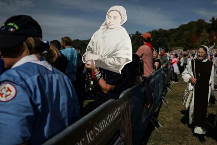 L'effigie de Bernadette Soubirous, la jeune bergère à qui la Vierge Marie serait apparue en 1858, lors de la messe célébrée par le pape Léon XIV sur la prairie du sanctuaire de Lourdes, le 27 septembre 2026 ( AFP / Valentine CHAPUIS )