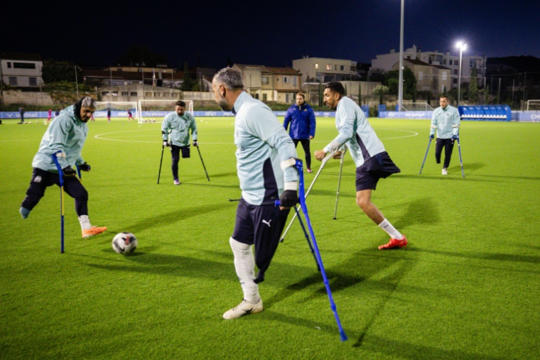 Des joueurs de l'équipe de l'OM des aputés s'affrontent lors d'une séance d'entraînement, le 22 novembre 2025 à Marseille ( AFP / CLEMENT MAHOUDEAU )