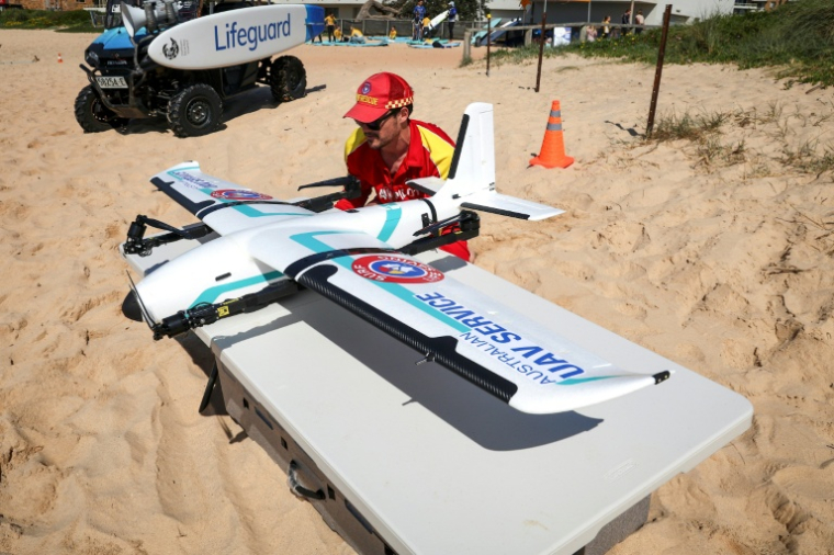 Le secouriste Oliver Heys prépare un grand drone de surveillance sur une plage à Sydney, le 1er octobre 2025 ( AFP / DAVID GRAY )
