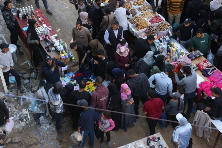 Des Palestiniens font leurs courses sur un marché de rue à Khan Younès, dans le sud de la bande de Gaza, le 17 mars 2026, alors qu'ils se préparent pour l'Aïd el-Fitr, la fête marquant la fin du mois sacré de jeûne musulman du Ramadan ( AFP / Bashar Taleb )
