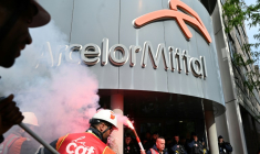 Des salariés d'ArcelorMittal rassemblés devant le siège du groupe à Saint-Denis, près de Paris, le 13 mai 2025 ( AFP / LEO VIGNAL )