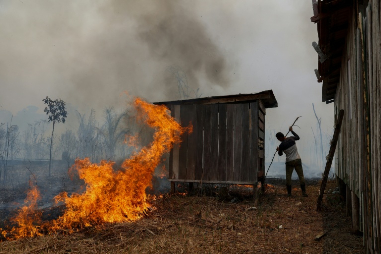 Un homme essaie de lutter contre le feu qui approche de sa maison à Autazes, dans l'État d'Amazonas au Brésil, le 9 octobre 2026 ( AFP / MICHAEL DANTAS )