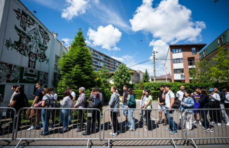 Des étudiants font la queue devant un bureau de vote pour le second tour de la présidentielle roumaine, le 18 mai 2025 à Bucarest ( AFP / Mihai Barbu )