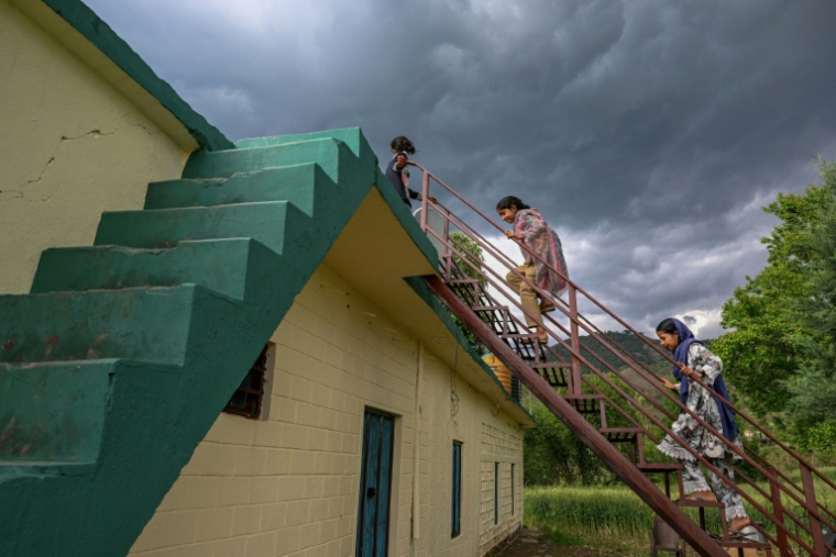 Des enfants montent sur le toit d'une maison dans le village de Kasaliyan, près de la frontière avec le Pakistan, le 6 avril 2026 en Inde ( AFP / Tauseef MUSTAFA )