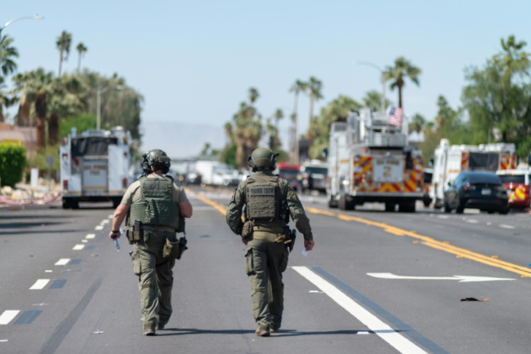Deux démineurs marchent près de la scène de l'explosion d'une bombe qui a endommagé une clinique spécialisée dans la procréation médicalement assistée (PMA) et fait un mort, le 17 mai 2025 à Palm Springs, en Californie ( AFP / Gabriel Osorio )