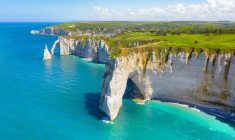 Les touristes se pressent sur la plage d‘Étretat en Seine-Maritime, sur les traces d’Arsène Lupin, popularisé dans le monde entier par la série Netflix. crédit photo : Shutterstock
