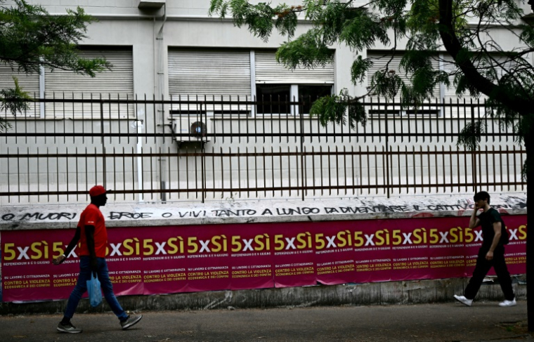 Des gens passent devant des affiches invitant à voter pour le référendum, à Rome, le 5 juin 2025 ( AFP / Filippo MONTEFORTE )