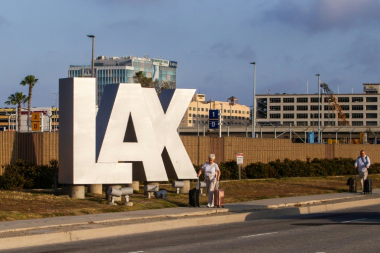 Des passagers avec leurs bagages près du Los Angeles International Airport (LAX), à Los Angeles, en Californie le 15 mai 2026 ( AFP / Apu GOMES )