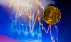 Pièce d'un rouble russe devant un écran affichant la tour Spasskaya du Kremlin à Moscou