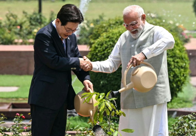 Le président sud-coréen Lee Jae-myung et le Premier ministre indien Narendra Modi, plante un arbre dans la résidence officielle du chef de gouvernement à New Dehli, le 20 avril 2026 ( AFP / Sajjad HUSSAIN )