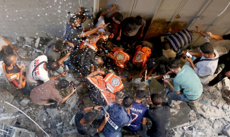 Des Paletsiniens dont des secouristes tentent de retrouver de survivants sur le site d'une frappe israélienne dans le quartier al-Rimal à Gaza-ville, le 30 août 2025 ( AFP / Omar AL-QATTAA )