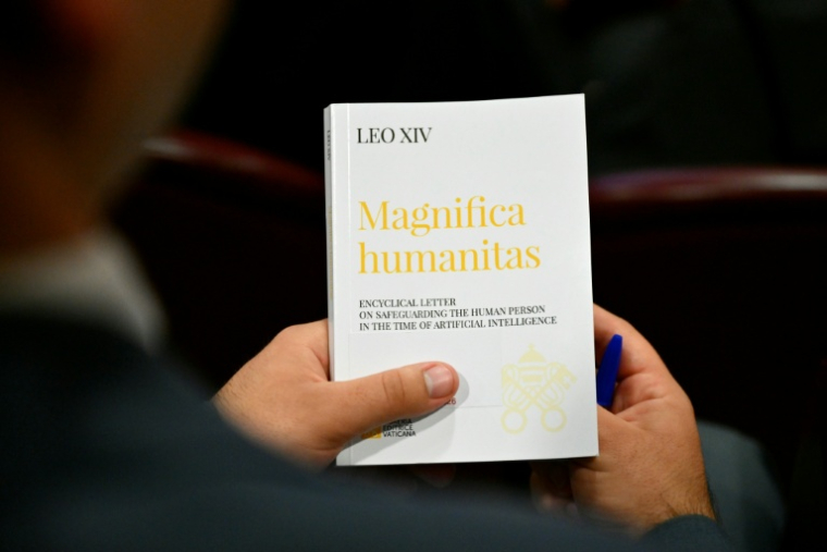 Une personne tient l'encyclique "Magnifica Humanitas" consacrée à l'essor de l'intelligence artificielle, le jour de sa promulgation par le pape Léon XIV, le 25 mai 2026 au Vatican  ( AFP / Alberto PIZZOLI )