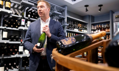 Michael Warner, cofondateur et directeur de DCanter, dans une boutique de vins affectés par les tarifs douaniers à Washington, le 19 août 2025 ( AFP / SAUL LOEB )
