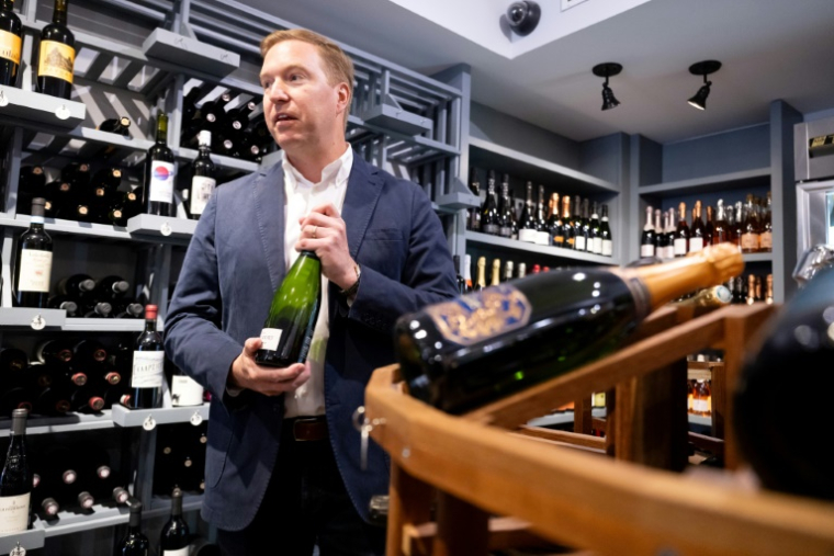 Michael Warner, cofondateur et directeur de DCanter, dans une boutique de vins affectés par les tarifs douaniers à Washington, le 19 août 2025 ( AFP / SAUL LOEB )