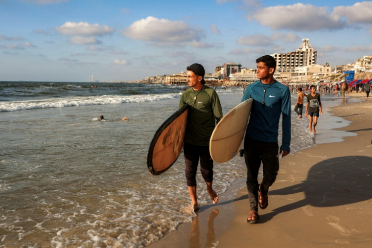 Des jeunes surfeurs palestiniens sur une plage de la ville de Gaza, le 21 juin 2026 ( AFP / Omar AL-QATTAA )