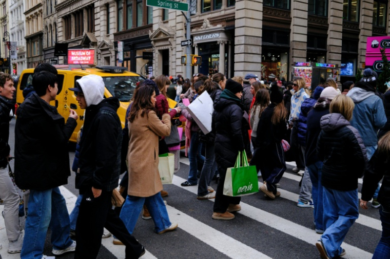 Des passants dans une rue animée du quartier de SoHo, à New York, le 21 décembre 2025 ( AFP / CHARLY TRIBALLEAU )