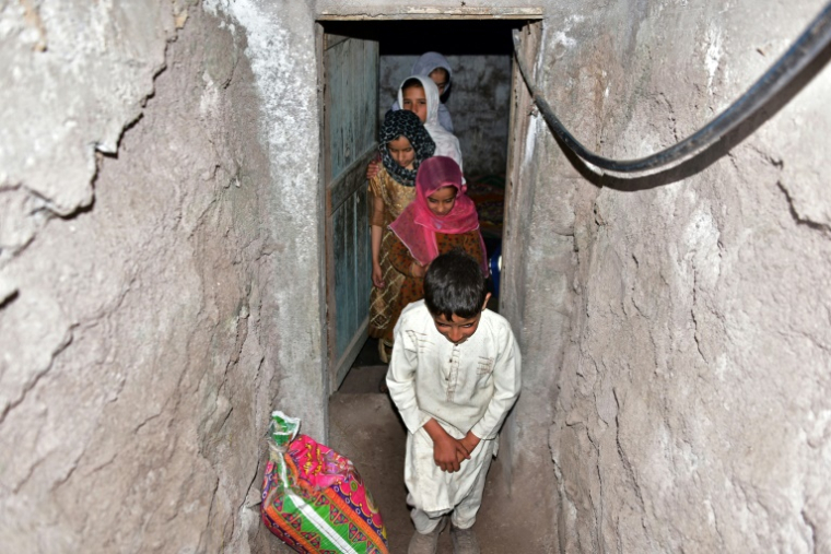 Une famille sort d'un bunker souterrain dans le village de Chakothi, au Cachemire sous administration pakistanaise, près de la ligne de contrôle (LoC), le 27 avril 2025 ( AFP / Sajjad QAYYUM )