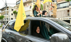 Des enfants tiennent des drapeaux du Hezbollah tandis que des habitants déplacés retournent dans leur quartier de la banlieue sud de Beyrouth après l'entrée en vigueur d'un cessez-le-feu de 10 jours avec Israël, le 17 avril 2026 au Liban ( AFP / FADEL itani )